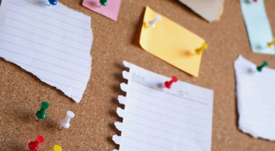 collection of colorful variety post. paper note reminder sticky notes pin on cork bulletin board. empty space for text.